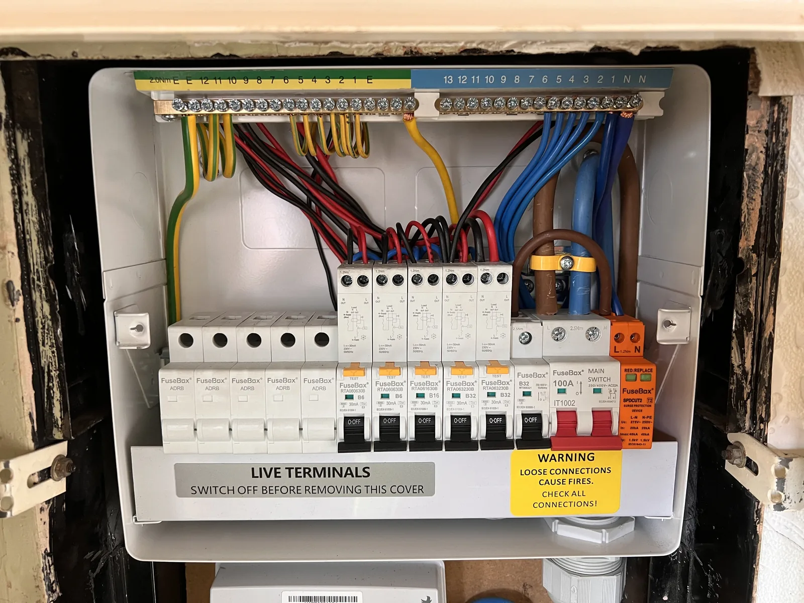 Open consumer unit showing neatly routed wiring and protective devices.