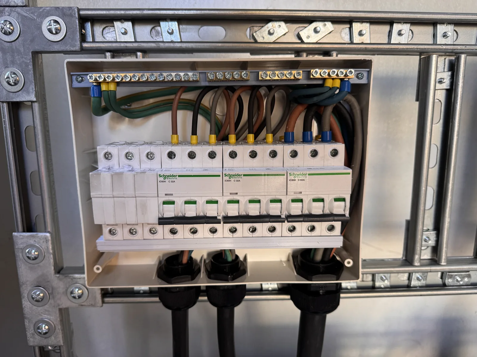 Three-phase protective devices and connections inside a distribution enclosure.